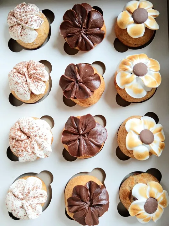 A box of buttercream-topped profiteroles